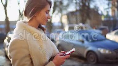 年轻漂亮的金发女郎走在街上，在许多汽车<strong>驶过</strong>的时候，她在智能手机上发短信。 她是